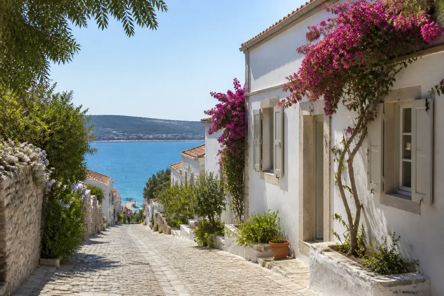 Çeşme’de beyaz evler ve taş duvarlarla sahil görünümü
